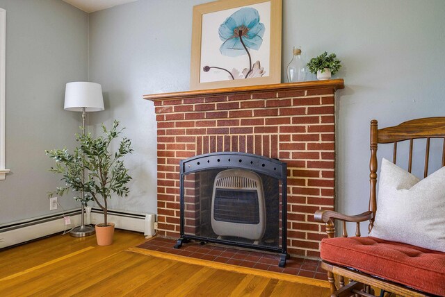 78 Stuart Ave, Stuarts Draft, VA 24477 - detailed view of wood finished floors, a baseboard heating unit, and a brick fireplace