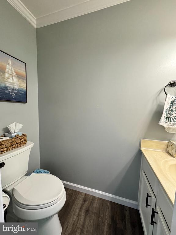 10010 Peppermill Ct, Fredericksburg, VA 22407 - half bathroom featuring wood finished floors, crown molding, baseboards, toilet, and vanity