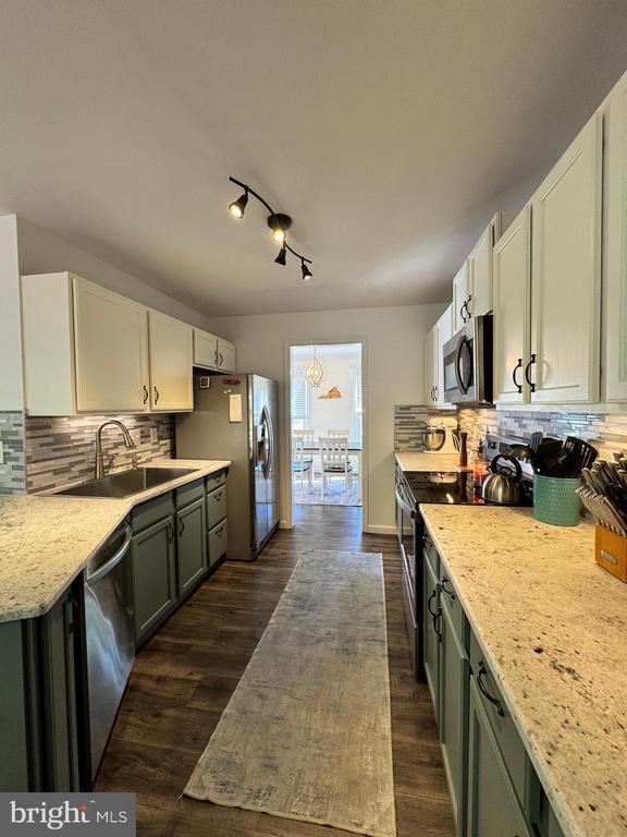 10010 Peppermill Ct, Fredericksburg, VA 22407 - kitchen featuring appliances with stainless steel finishes, a sink, dark wood-style flooring, and decorative backsplash