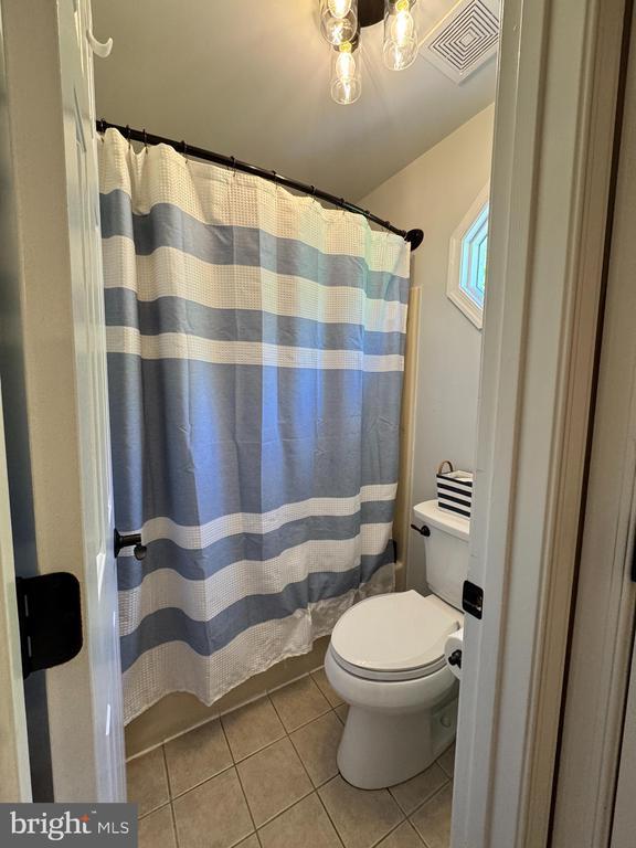 10010 Peppermill Ct, Fredericksburg, VA 22407 - bathroom with tile patterned flooring, toilet, a chandelier, and a shower with shower curtain