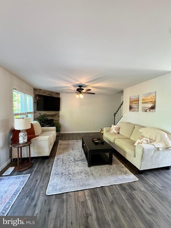 10010 Peppermill Ct, Fredericksburg, VA 22407 - living area featuring wood finished floors, a ceiling fan, baseboards, and a large fireplace