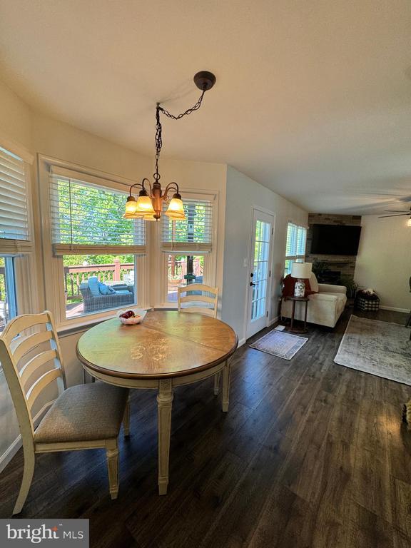 10010 Peppermill Ct, Fredericksburg, VA 22407 - dining space with dark wood-type flooring, a chandelier, a ceiling fan, and baseboards