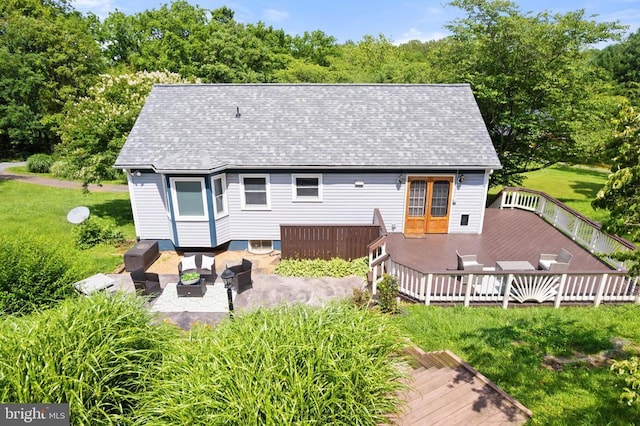  - back of house featuring a wooden deck, roof with shingles, and a yard
