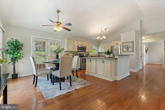  - dining area with a chandelier, ceiling fan, lofted ceiling, and hardwood / wood-style flooring
