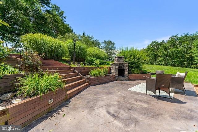  - view of patio / terrace featuring an outdoor stone fireplace