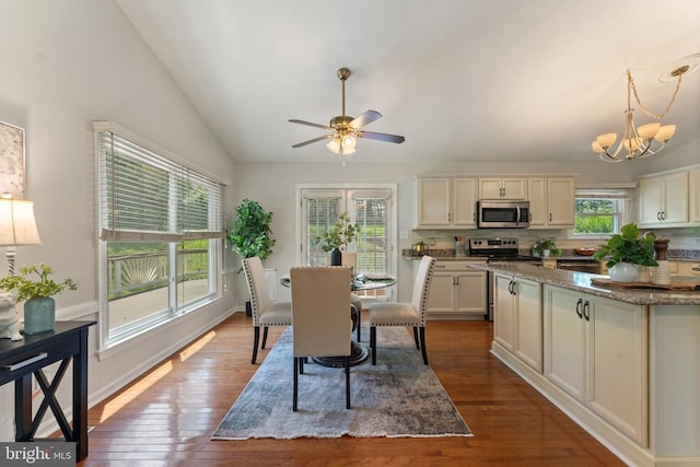  - dining space featuring vaulted ceiling, dark wood-type flooring, a chandelier, and ceiling fan