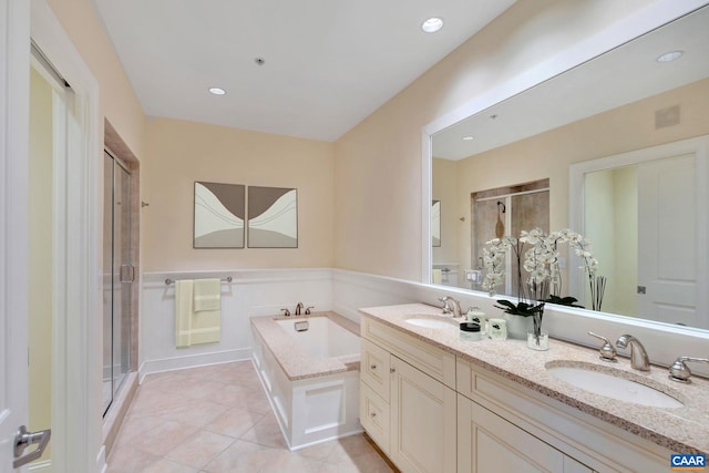 bathroom featuring a garden tub, tile patterned flooring, a shower stall, and a sink