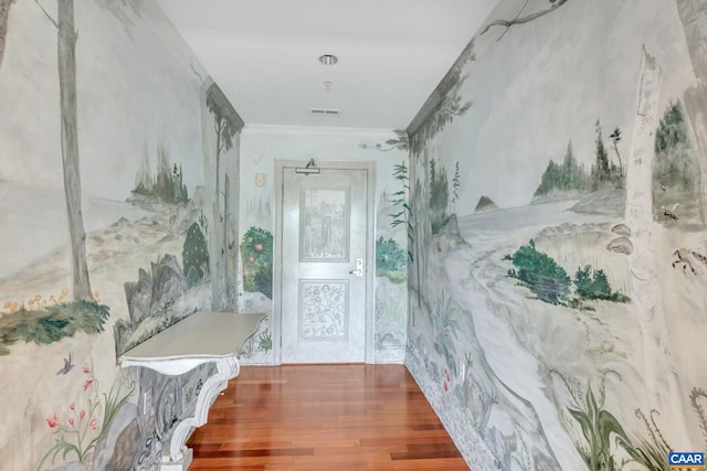 hall with crown molding, wallpapered walls, and wood finished floors