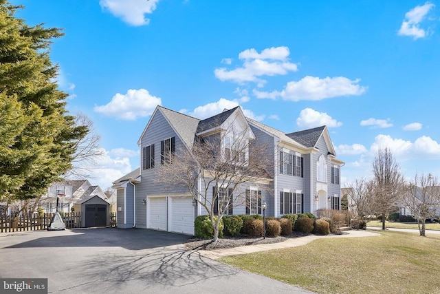 view of side of property with a garage and asphalt driveway