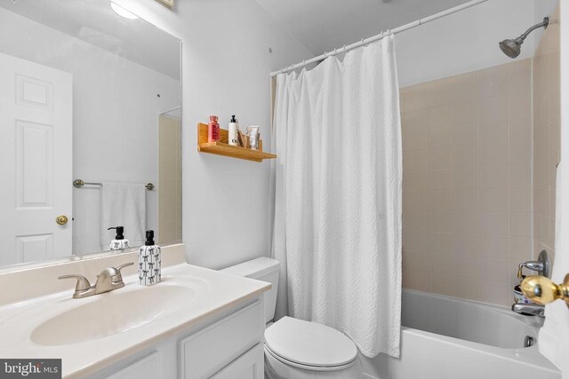 bathroom with toilet, shower / tub combo with curtain, and vanity