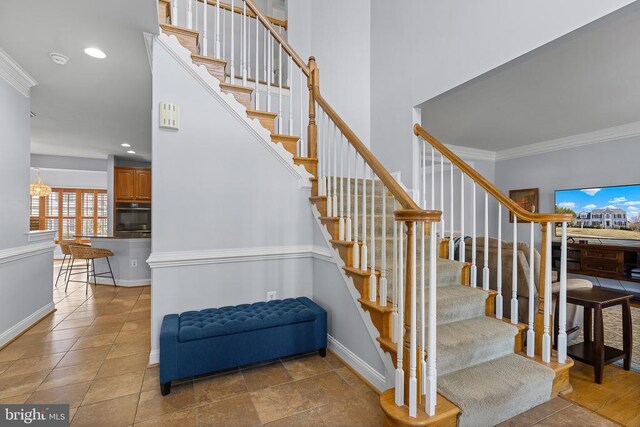 stairs featuring baseboards, ornamental molding, and recessed lighting