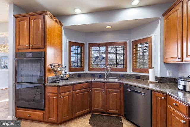 kitchen featuring dishwasher, a sink, brown cabinets, and recessed lighting