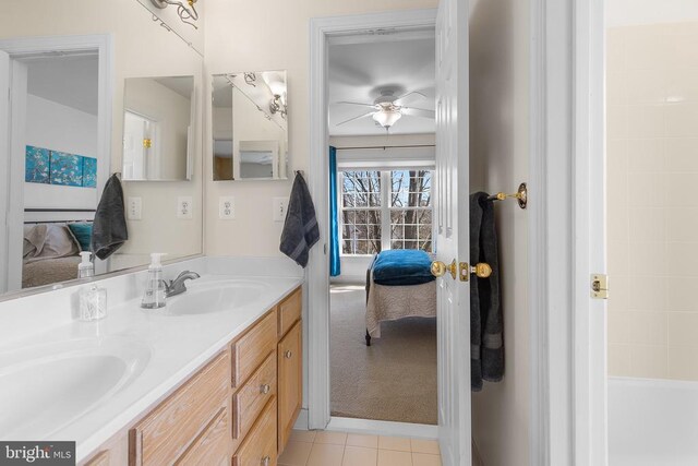 full bath with ensuite bathroom, tile patterned floors, a ceiling fan, double vanity, and a tub to relax in