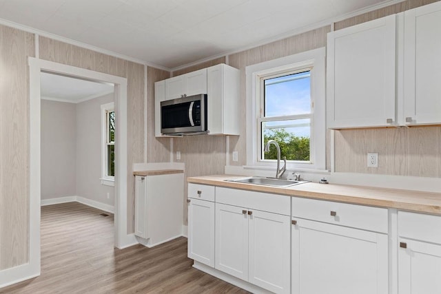 837 Faber Ave, Waynesboro, VA 22980 - kitchen featuring a sink, stainless steel microwave, ornamental molding, light wood-style floors, and light countertops