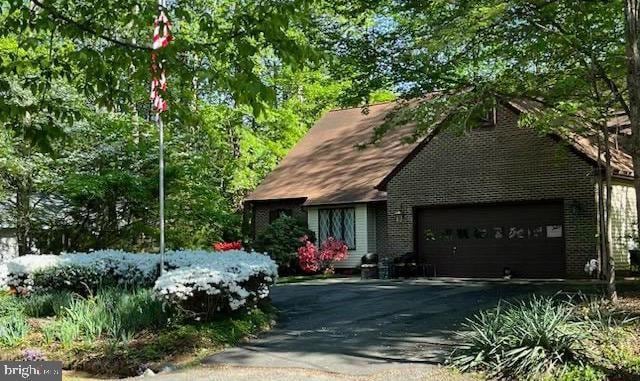 view of front of property featuring asphalt driveway and an attached garage