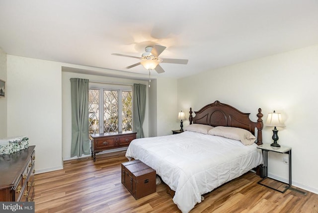 bedroom with wood finished floors, baseboards, and a ceiling fan