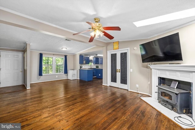 13602 Flank March Ln, Spotsylvania, VA 22551 - unfurnished living room featuring baseboards, dark wood finished floors, ceiling fan, crown molding, and a wood stove