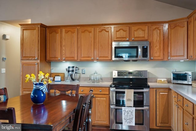 5585 Sperryville Pike, Boston, VA 22713 - kitchen with stainless steel appliances, light countertops, brown cabinets, and vaulted ceiling