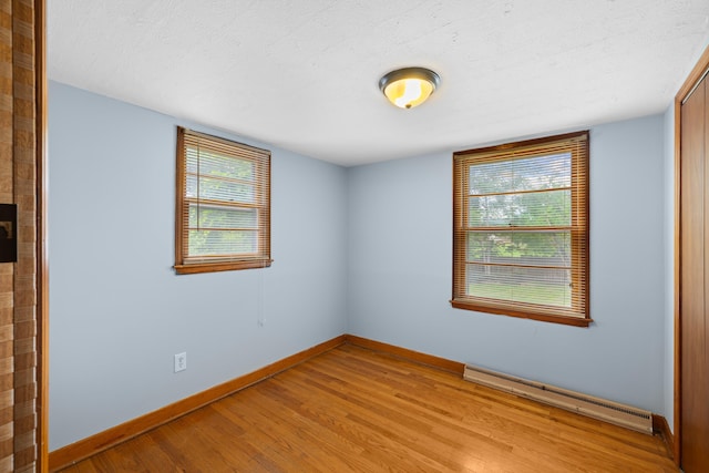 2403 Bare St, Staunton, VA 24401 - unfurnished room featuring a baseboard heating unit, light wood-type flooring, plenty of natural light, and a textured ceiling