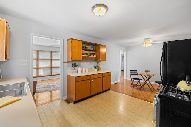 2403 Bare St, Staunton, VA 24401 - kitchen with range with gas stovetop, freestanding refrigerator, light countertops, open shelves, and brown cabinetry