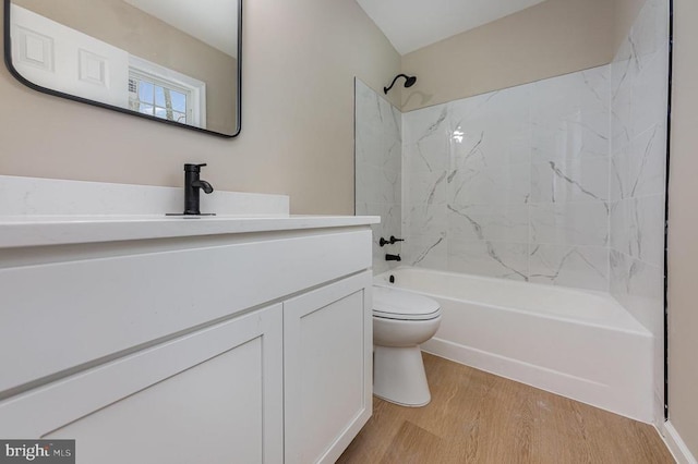 full bathroom featuring wood-type flooring, toilet, vanity, and tiled shower / bath