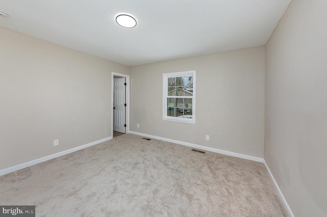 unfurnished room featuring light carpet