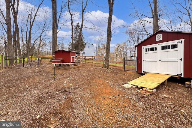 view of yard featuring exterior structure, fence, a storage shed, and an outbuilding