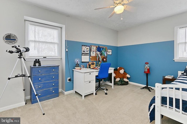 bedroom featuring baseboards, light carpet, and a textured ceiling