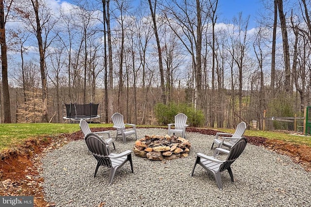 view of patio featuring an outdoor fire pit and a trampoline