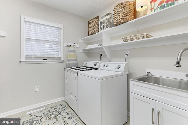 washroom with washer and dryer, cabinet space, baseboards, and a sink