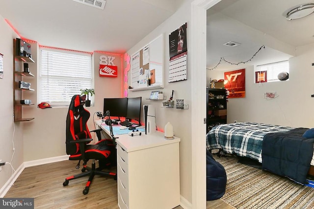home office with baseboards, light wood-style floors, visible vents, and plenty of natural light