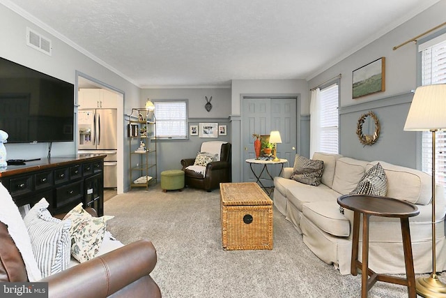 living area featuring crown molding, light carpet, a textured ceiling, and visible vents