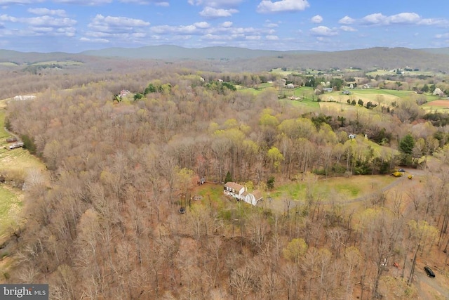 birds eye view of property featuring a mountain view and a wooded view