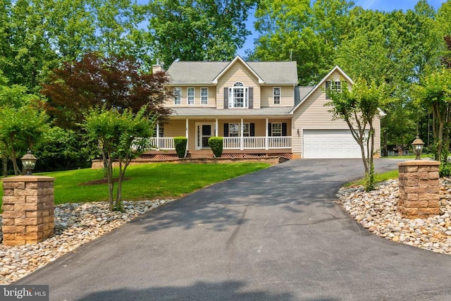 7221 Crockett Ave, Rapidan, VA 22733 - colonial-style house with asphalt driveway, covered porch, a front yard, a garage, and a chimney