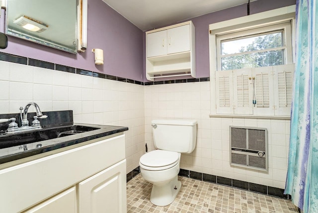 340 New York Ave, Harrisonburg, VA 22801 - bathroom featuring heating unit, tile walls, vanity, and a wainscoted wall