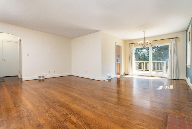 340 New York Ave, Harrisonburg, VA 22801 - unfurnished living room featuring arched walkways, a chandelier, and dark wood-style floors