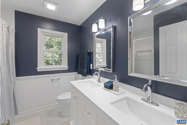 102 Powhatan Cir, Charlottesville, VA 22901 - bathroom featuring toilet, double vanity, a shower with curtain, a wainscoted wall, and tile patterned floors