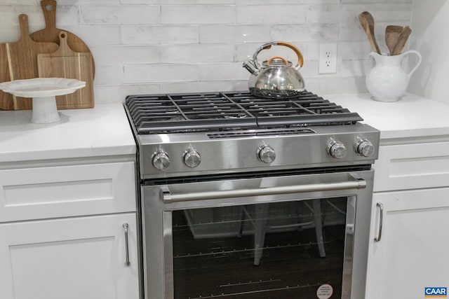 102 Powhatan Cir, Charlottesville, VA 22901 - kitchen view of stainless steel gas range, white cabinetry, backsplash, and light stone counters