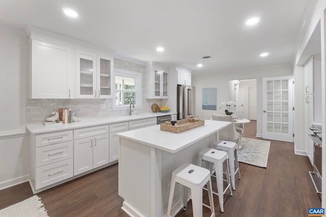 102 Powhatan Cir, Charlottesville, VA 22901 - kitchen featuring appliances with stainless steel finishes, a breakfast bar area, a sink, white cabinetry, and crown molding