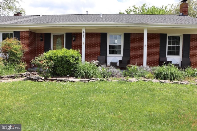 ranch-style house with a chimney and brick siding