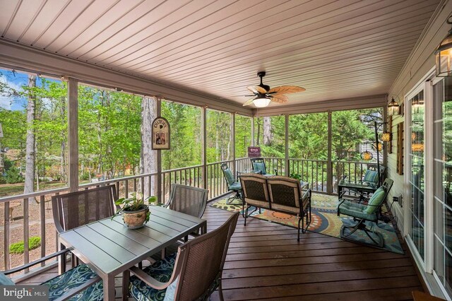 sunroom featuring a ceiling fan, outdoor dining area, and an outdoor living space
