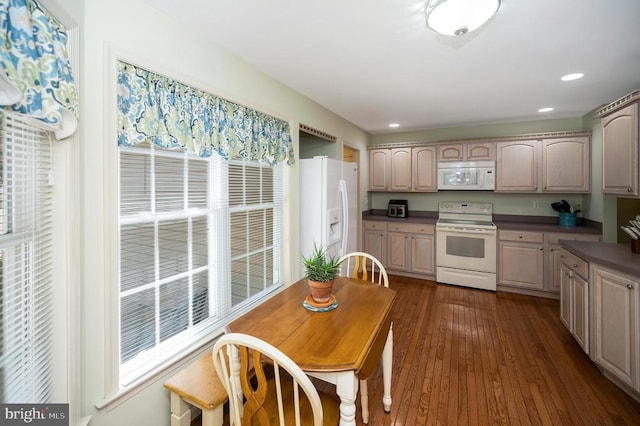 kitchen with white appliances, dark countertops, dark wood finished floors, recessed lighting, and light brown cabinets