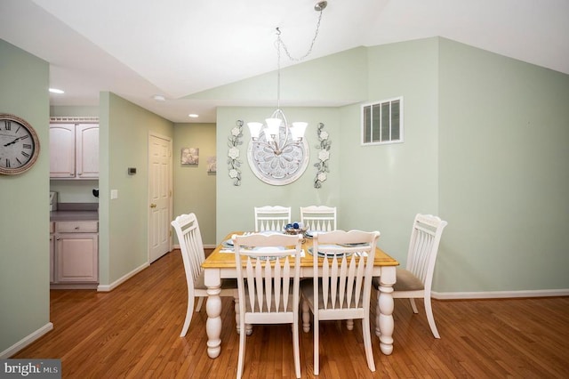 dining area featuring light wood finished floors, a chandelier, recessed lighting, baseboards, and vaulted ceiling
