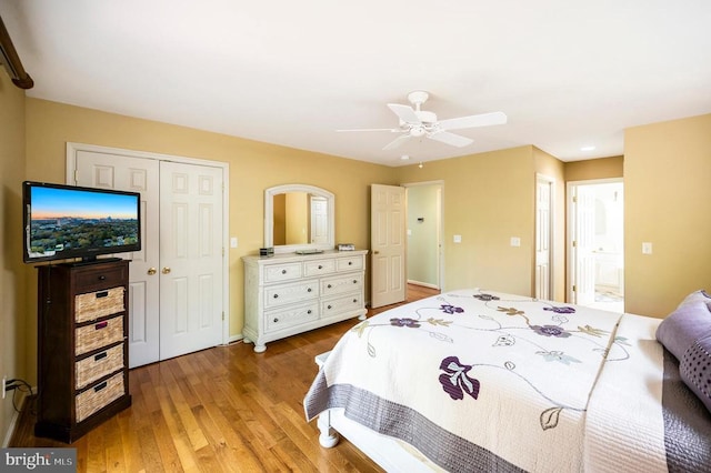 bedroom with wood finished floors, a ceiling fan, and ensuite bath