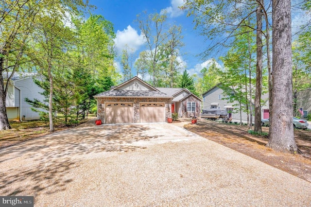 view of front of house with driveway, an attached garage, and stone siding