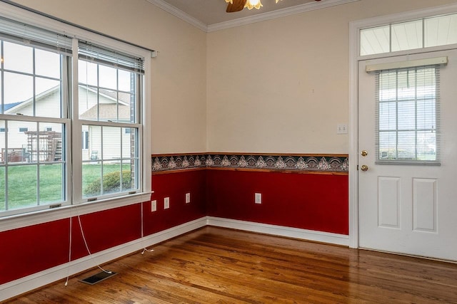unfurnished room featuring visible vents, crown molding, plenty of natural light, and wood finished floors
