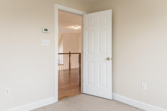 interior space with baseboards and light carpet