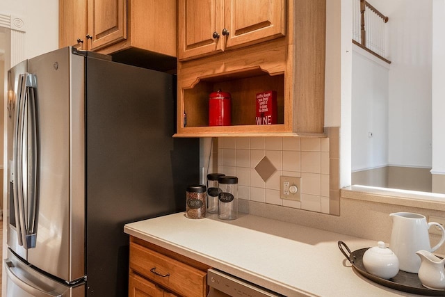 kitchen with brown cabinetry, open shelves, decorative backsplash, stainless steel fridge, and light countertops
