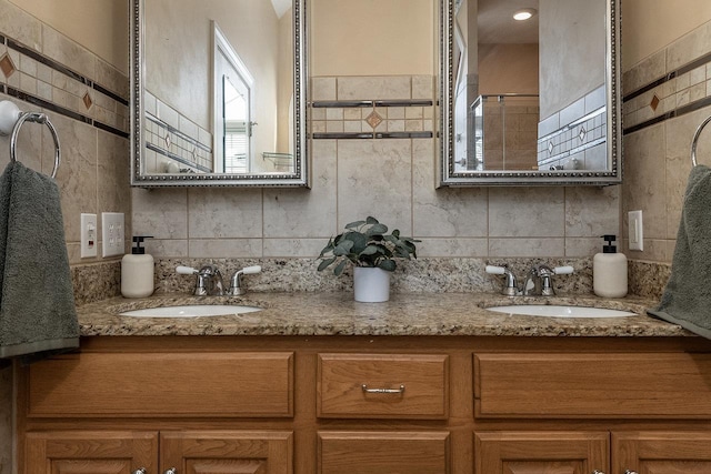 full bath featuring a sink, double vanity, and tile walls