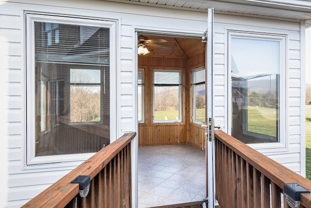 unfurnished sunroom featuring a ceiling fan